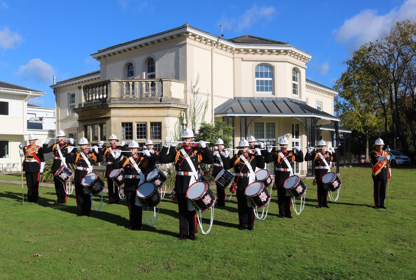 The Ceremonial Unit holding instruments at Service Headquarters in full black uniform, wearing white helmets.