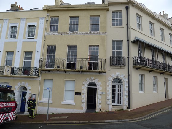 four storey terraced building with fire engine parked in front