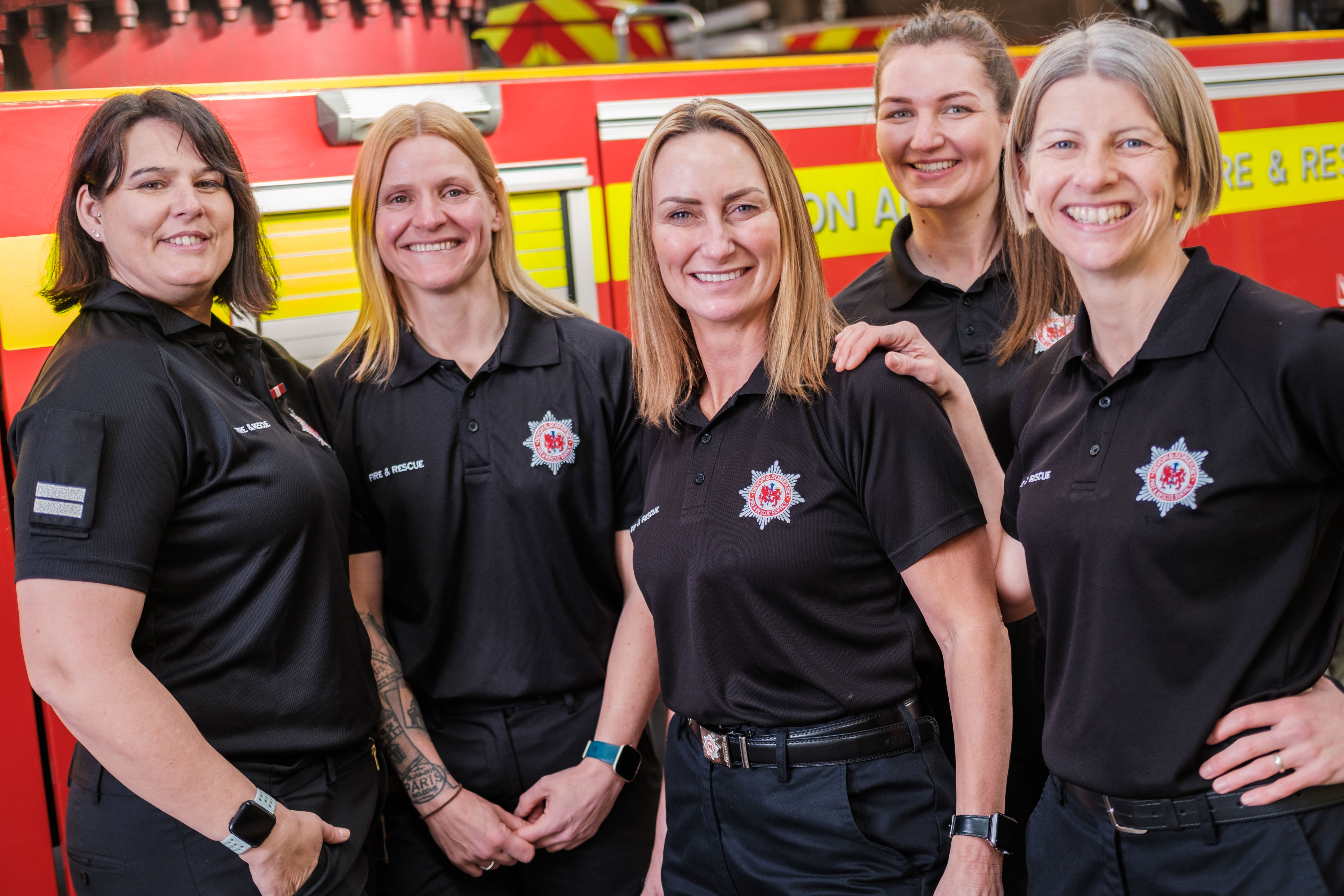 Five female firefighters in front of a fire engine