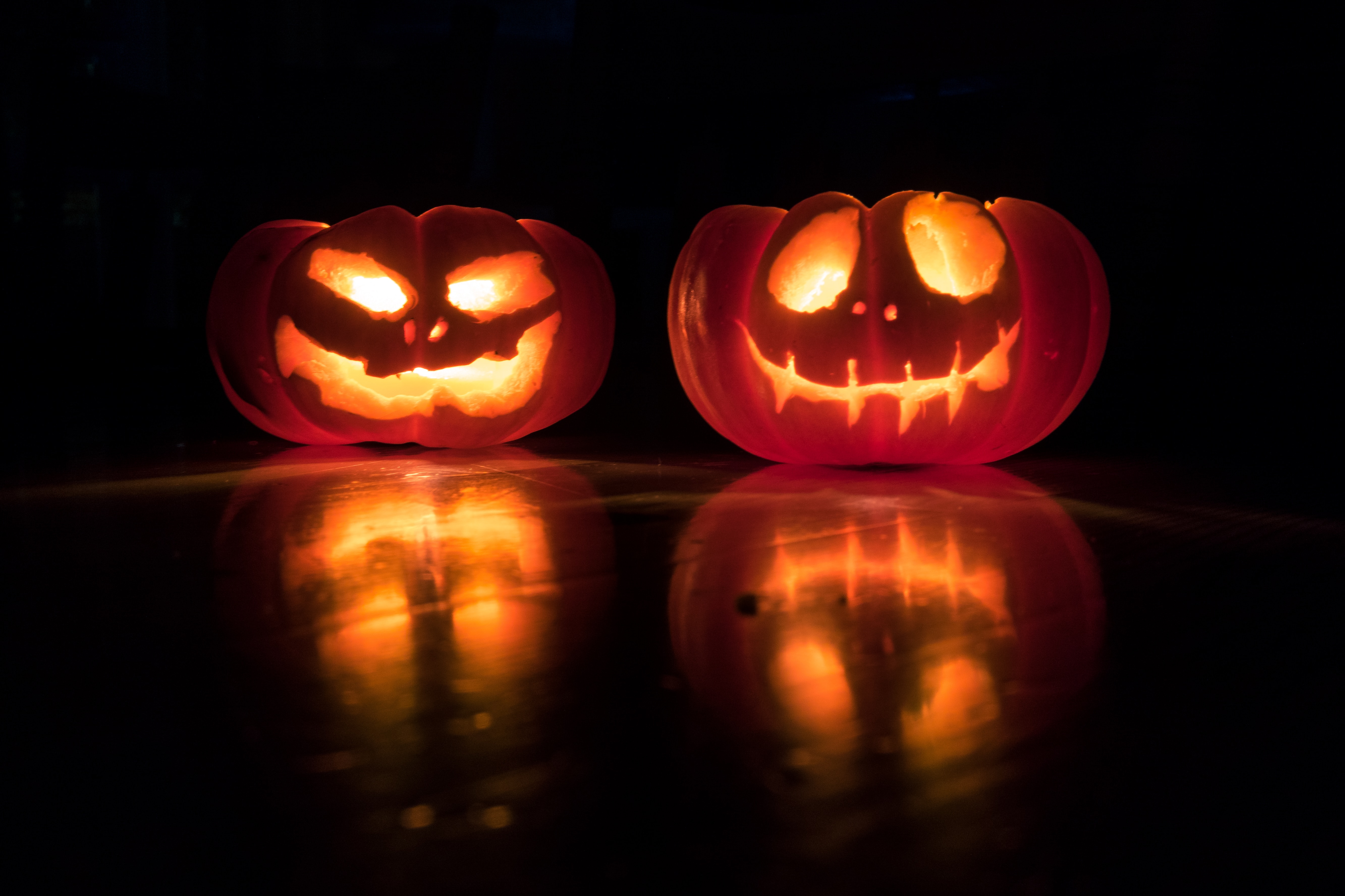 Two Halloween pumpkins, lit from inside