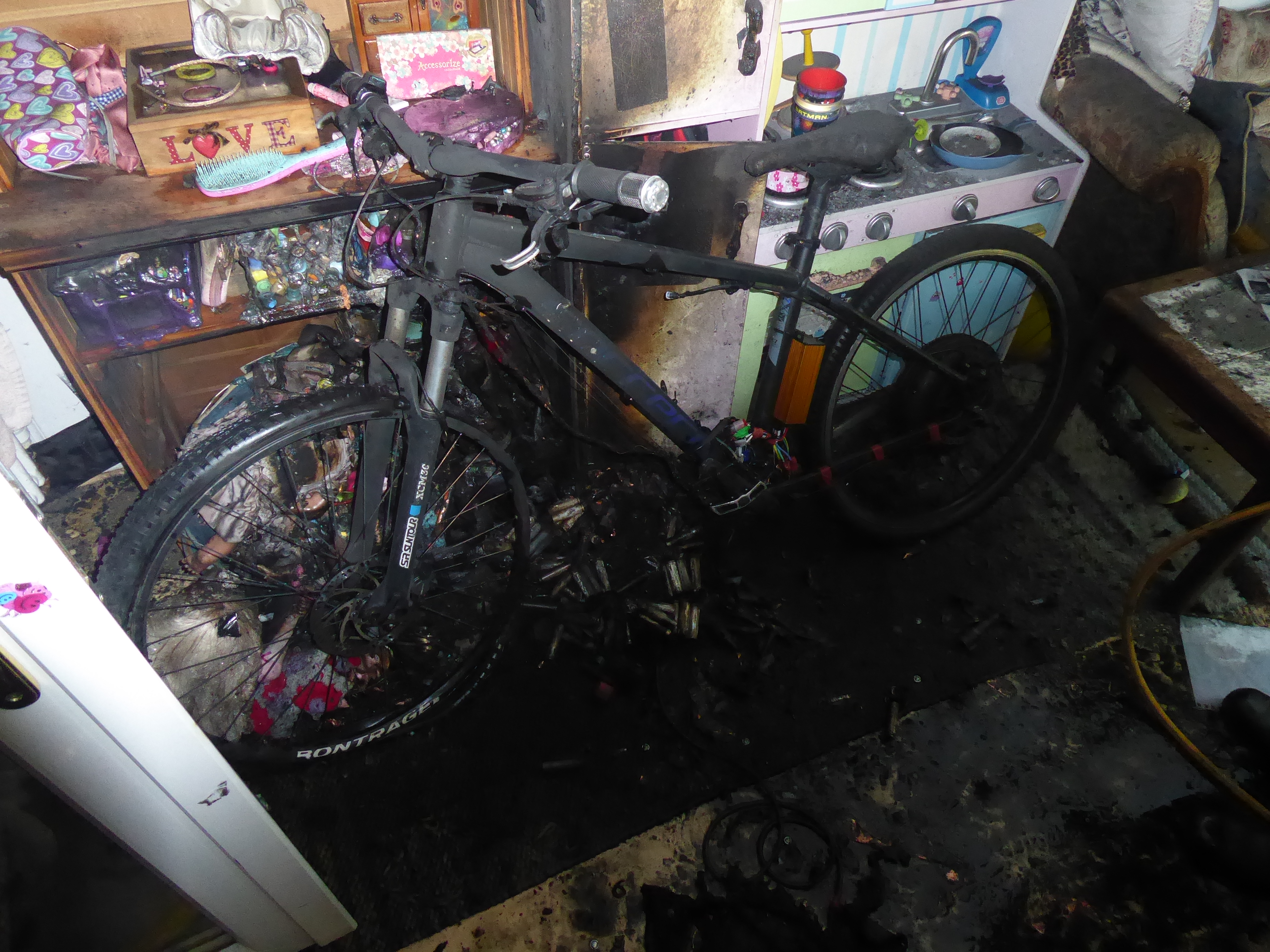 An e-bike and room damaged by a lithium-ion battery fire