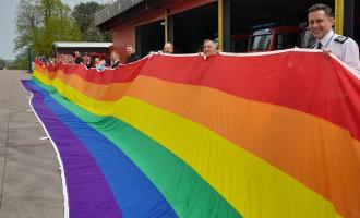 Colleagues holding the rainbow flag at Service Headquarters