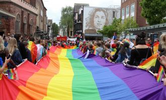 The rainbow flag being carried down Exeter High Street