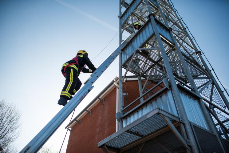 Potential firefighter climbing a ladder
