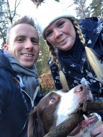 A selfie of Martin and Lauren with their brown and white dog.