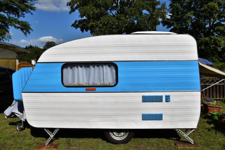 A white caravan with a blue stripe along the middle.