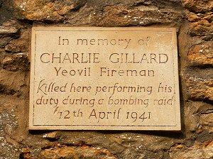A plaque on a stone wall which reads "In memory of Charlie Gillard, Yeovil Fireman. Killed here performing his duty during a bombing raid. 12th April 1941."