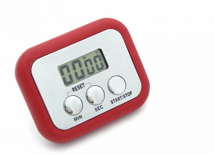 A red and silver cooking timer with a digital screen and three buttons at the bottom. The digits display zeros.