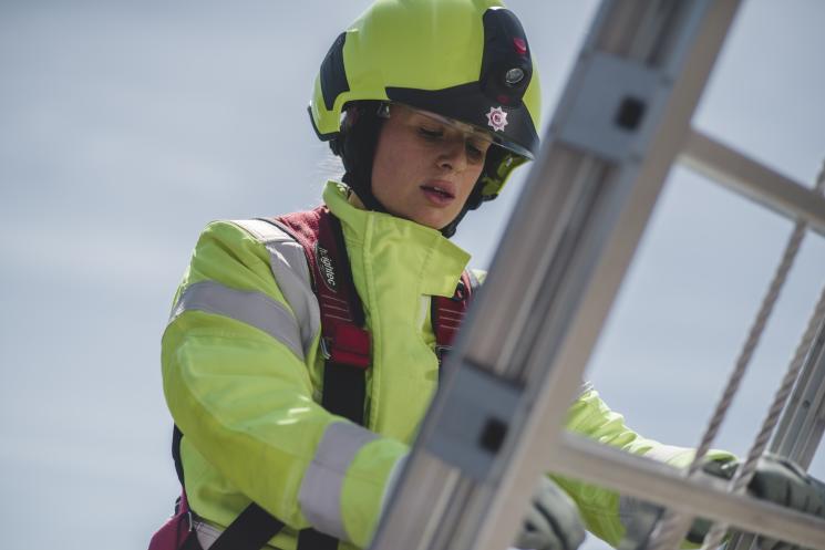 A female firefighter on a ladder