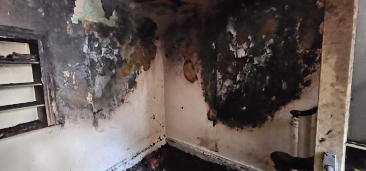 Charred and fire damaged walls and floor following a fire involving an e-bike