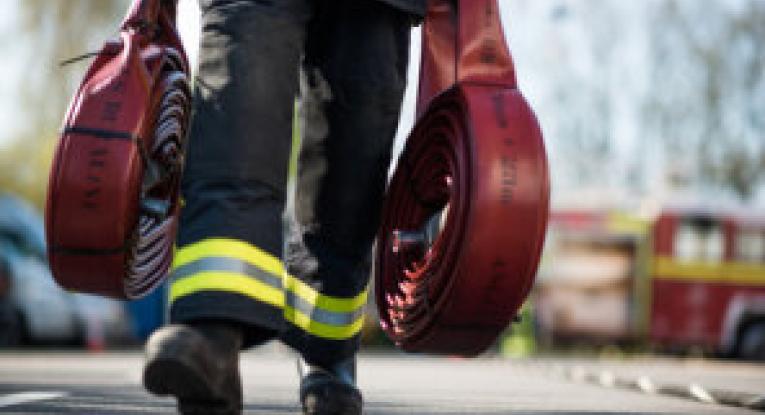 A Firefighter carrying hoses